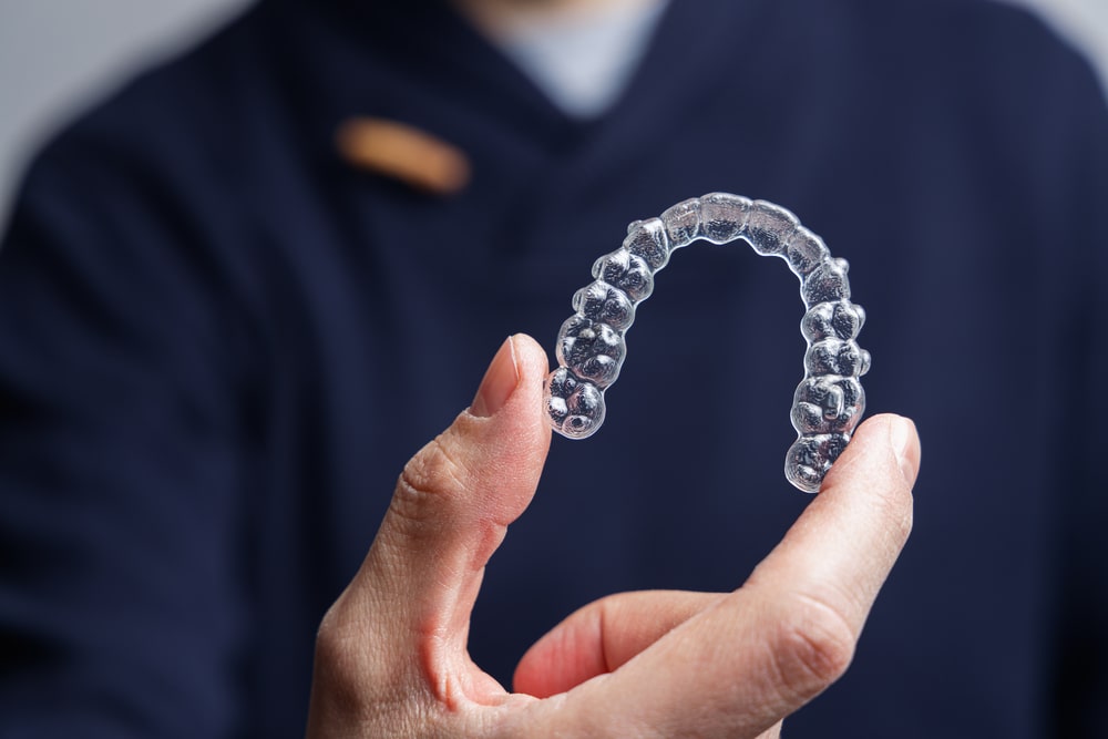 Hand showing Invisalign for teeth straightening